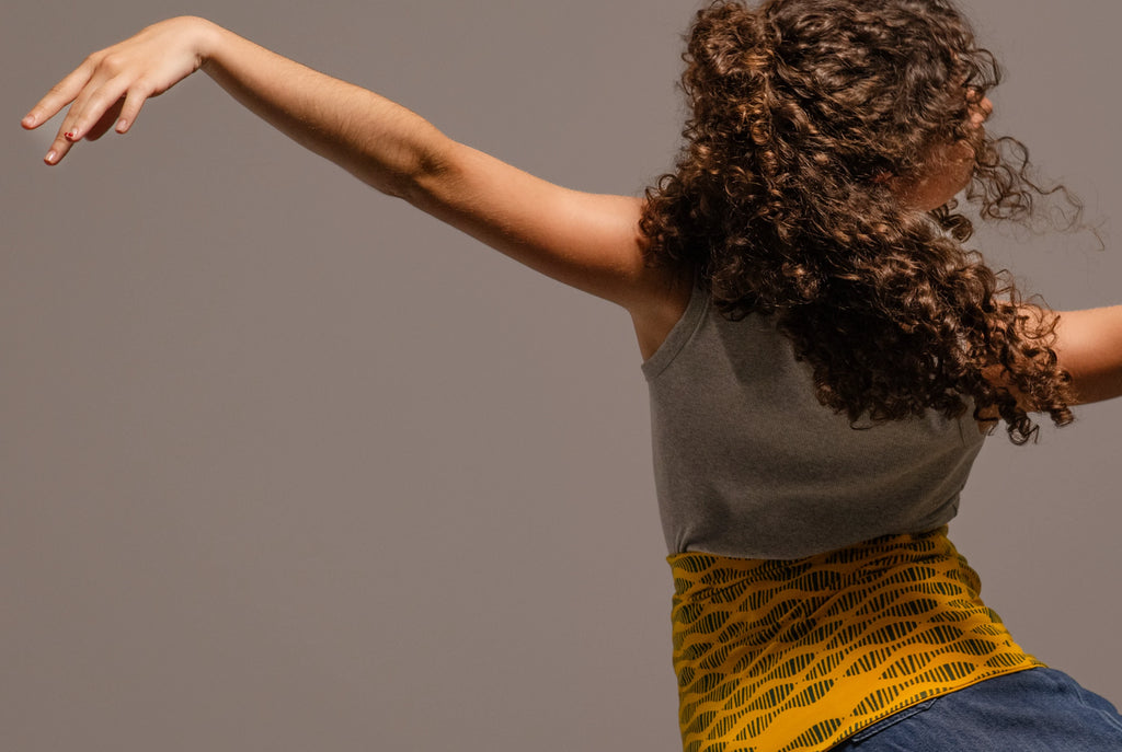 Bailarina de espaldas saltando con el haramaki estampado amarillo de Happy Belly Barcelona