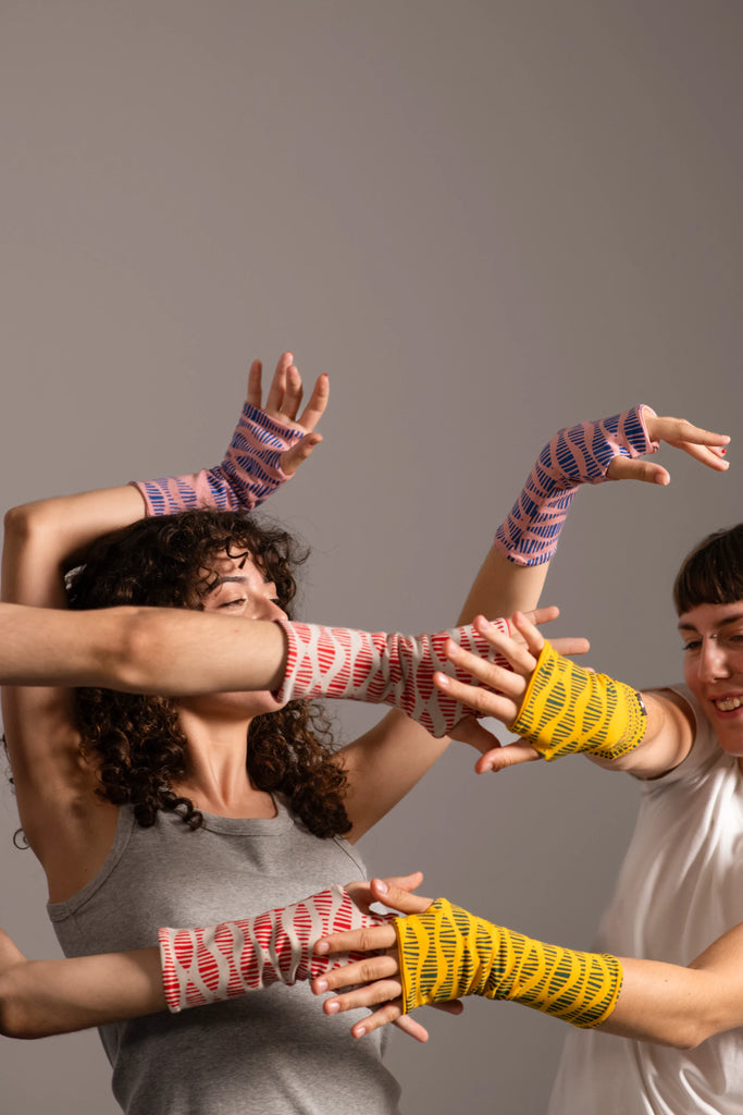 Baile de manos mostrando los mitones estampados de Happy Belly Barcelona