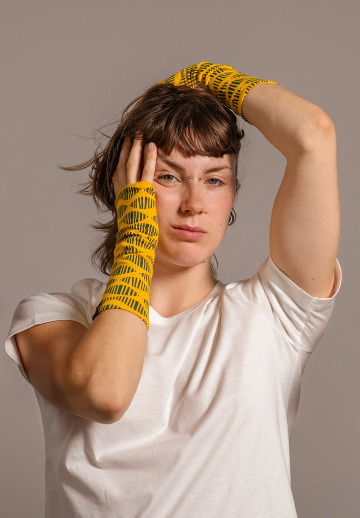 Chica recogiendo el pelo con mitones estampados amarillos de Happy Belly Barcelona