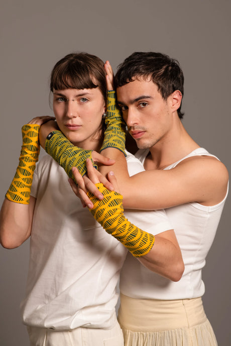 Retrato de pareja joven mostrando los mitones estampados de Happy Belly Barcelona