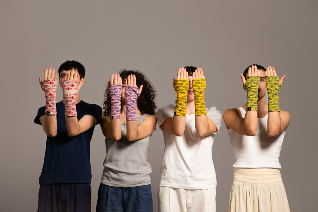 Grupo de cuatro personas mostrando las manos con los mitones estampados de Happy Belly Barcelona