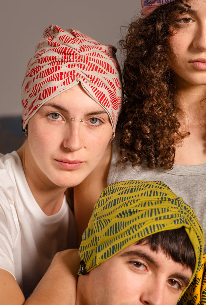 Jóvenes mirando a cámara llevando los turbantes estampados de Happy Belly Barcelona