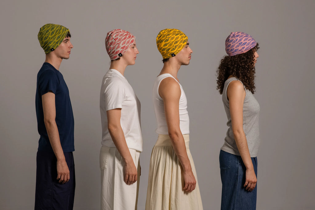 Cuatro jóvenes de perfil con turbantes estampados de colores alegres de Happy Belly Barcelona