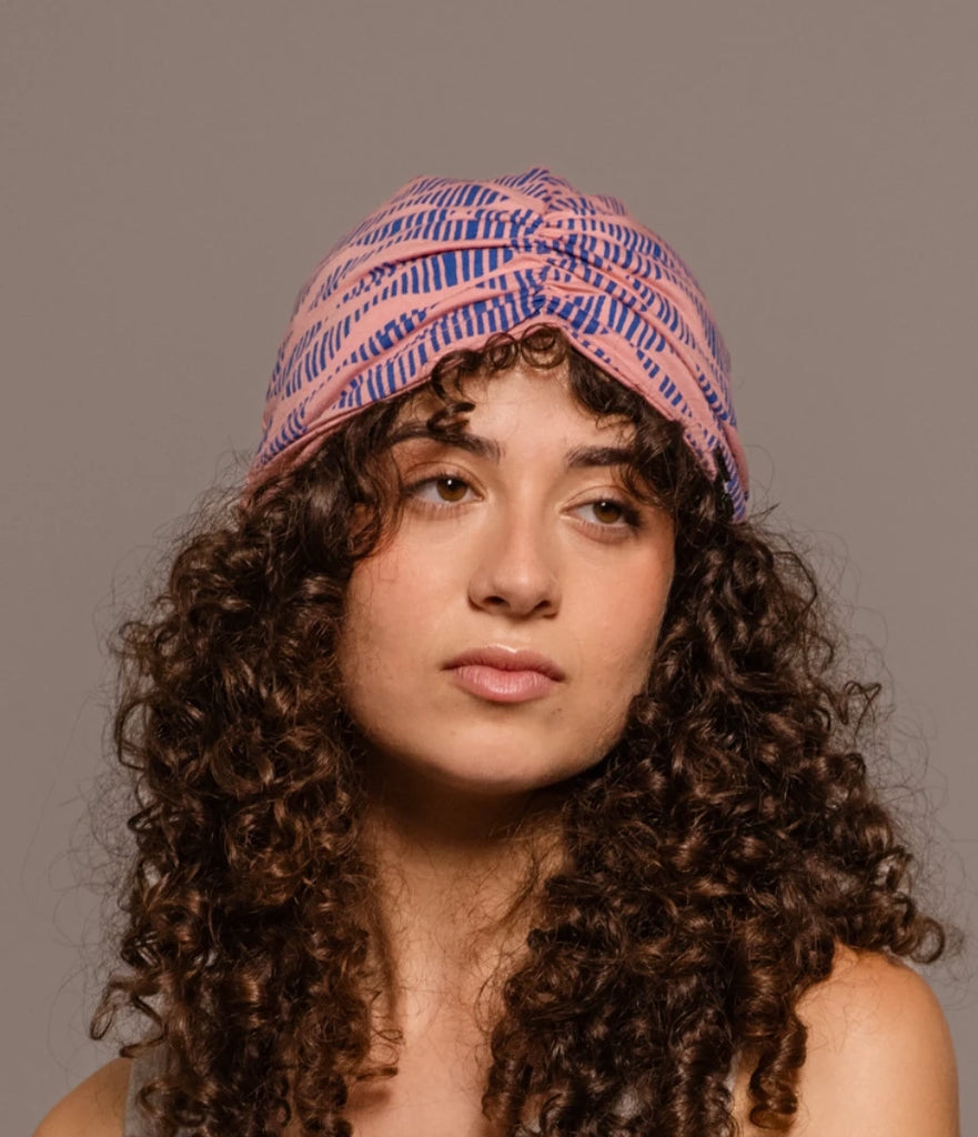 Retrato de chica pensativa llevando un turbante estampado de Happy Belly Barcelona