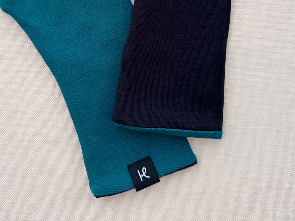 Detalle de mitones reversibles turquesa y negro de algodón orgánico de Happy Belly