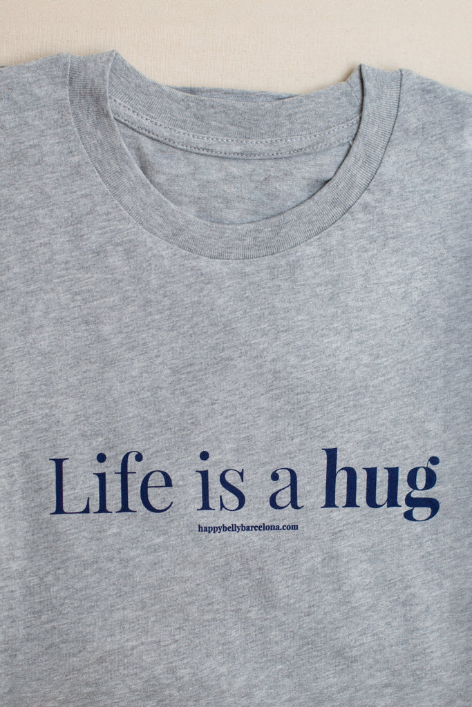 Detalle Camiseta algodón orgánico color gris claro con lema Life is a hug en azul