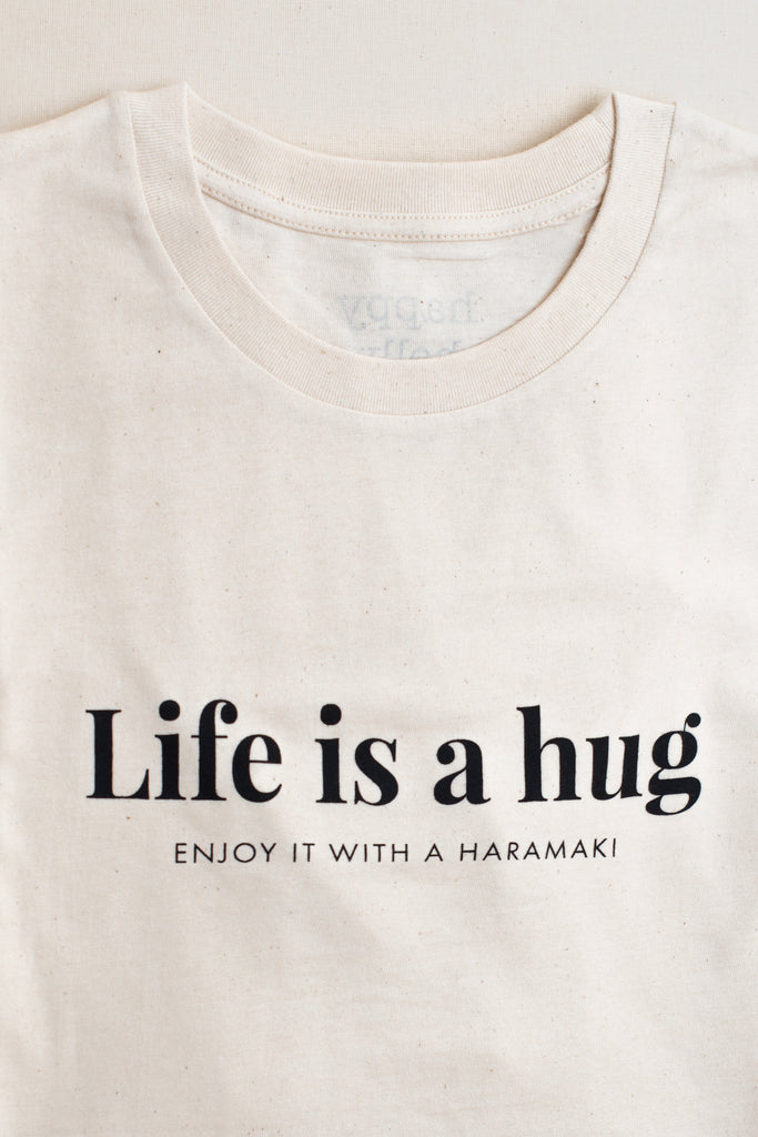 Detalle camiseta algodón orgánico color natural con lema Life is a hug en negro