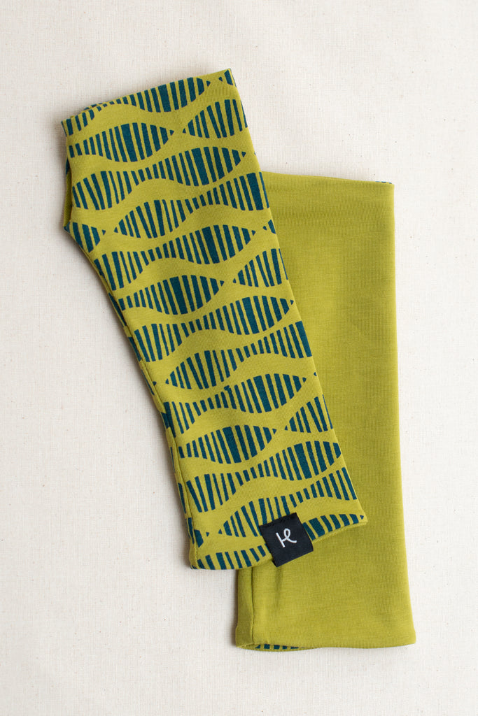 Pareja de mitones reversibles color lima, estampados en turquesa con serigrafía, marca Happy Belly