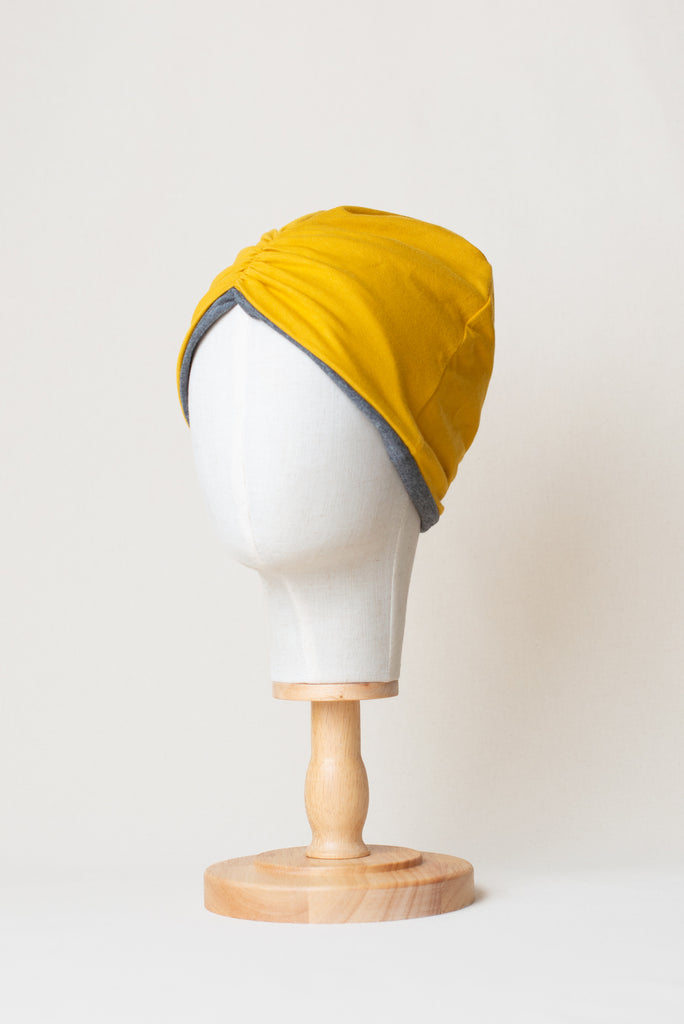Turbante reversible de color amarillo mostaza de algodón orgánico, marca Happy Belly